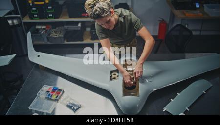 Well Lit, Organized Drone Factory Features Several Stations Where Engineers Assembling Large UAVs. Concept of Assembly For UAV, Streamlined, Systematic Approach to Modern Defense Production. Top View. Stock Photo