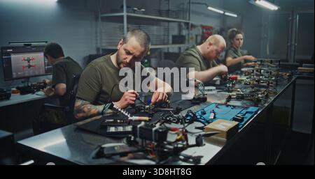 Modern Manufacturing Facility Bustles With Skilled Workers Various Stations, Building FPV Drones. Concept of Precision and Complexity of Modern Industrial Production and Technological Advancement. Stock Photo