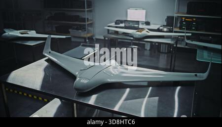 Flying Wing Design Multiple Tactical UAV on Production Tables. Several UAV Featuring Flying Wing Design Placed in Industrial Environment. Concept of Modern Aerodynamic Design and Production Readiness. Stock Photo