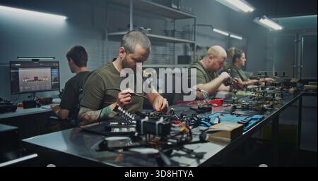 Drone Engineering on Factory. Full Drone Engineering Process, From 3D Design on Computer Hands on Soldering and Assembly. Concept of Integrated Workflow in Cutting Edge UAV Production Facility. Stock Photo