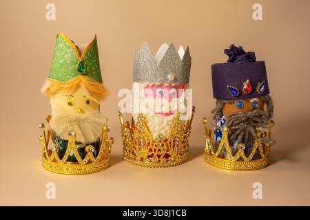 Three handmade Three Kings figurines with colorful crowns and gift boxes symbolize Epiphany celebration on January 6 Stock Photo