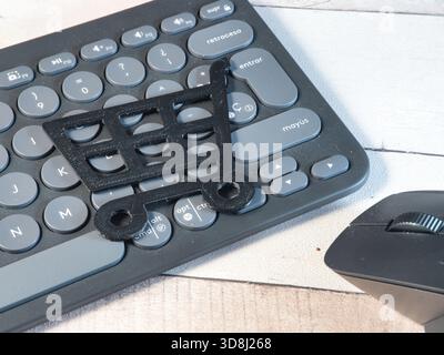 Online Shopping Cart on Keyboard - 3D-printed shopping cart icon on a modern gray wireless keyboard with a mouse. Perfect for e-commerce, digital reta Stock Photo