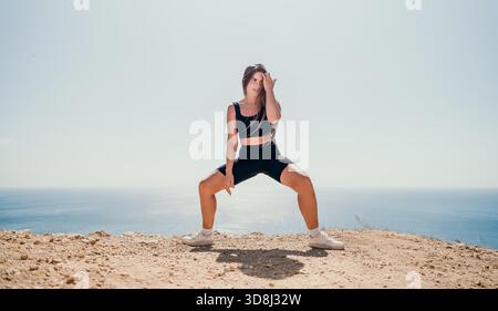 Woman in Black Sportswear Posing on a Cliff by the Ocean Stock Photo