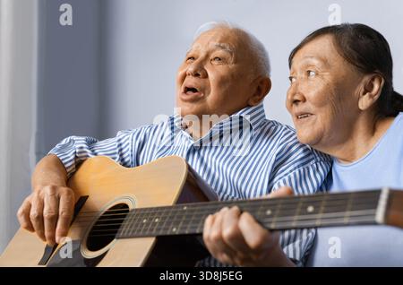 Senior man playing acoustic guitar with his wife Stock Photo