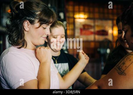 Women friends enjoying candid moment together in bar Stock Photo