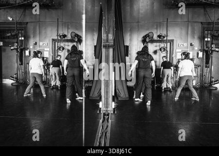 Dancers rehearsing in studio with mirror reflection Stock Photo