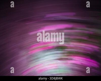 Abstract motion blur creating streaks of purple, pink, and white light, forming a captivating swirling pattern with dynamic movement and vibrant energ Stock Photo