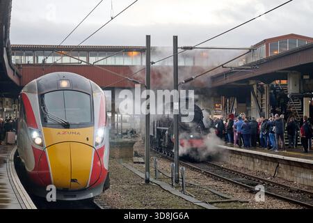 LNER Azuma adjacent to a Railway Enthusiasts Steam Train Charter at York railway station, North Yorkshire, Northern England, UK Stock Photo