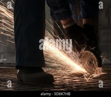 Work of electric saw for metal shot in studio being repaired sparks all around worker Stock Photo