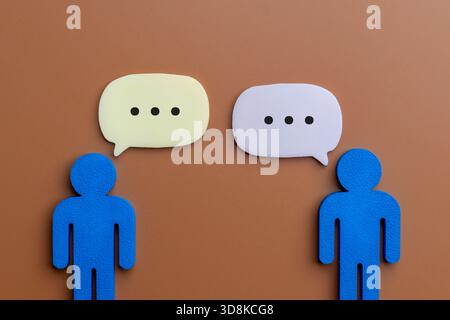 Two human-shaped icons facing each other with speech bubbles. Communication, dialogue, conversation, negotiation, public relations Stock Photo
