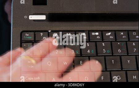 Ghost hand touching computer keyboard with international symbols Stock Photo