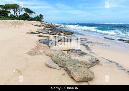 Crashing waves on rocks on beautiful tropical white sandy Marosi beach on the southern coastline of Sumba island, Indonesia Stock Photo