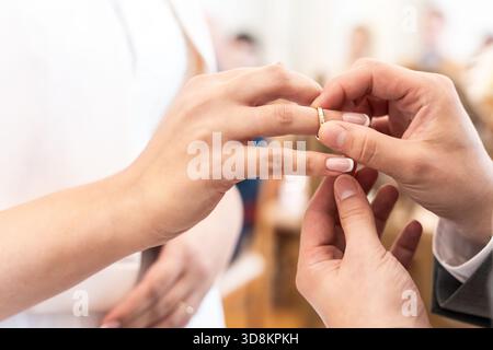 Bride And Groom Exchanging Wedding Rings During Ceremony With Close-Up On Hands And Gold Bands Symbolizing Marriage Stock Photo