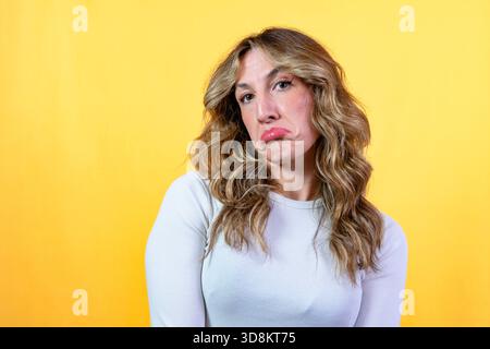 Woman making a sad face, pouting her lips demonstrating disappointment Stock Photo