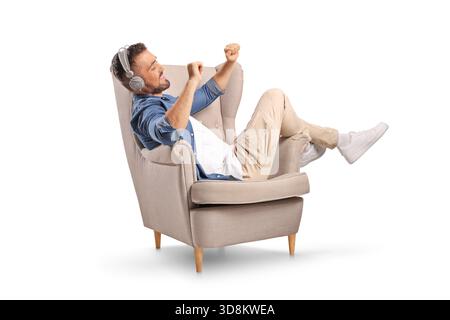Man relaxing in an armchair and listening to music isolated on white background Stock Photo