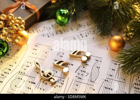 Golden music notes, sheets and Christmas decor on table, closeup Stock Photo