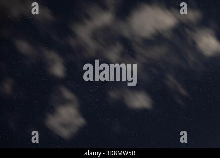 Dark night in North Carolina with the sky filled with stars and fast moving clouds in between. Stock Photo