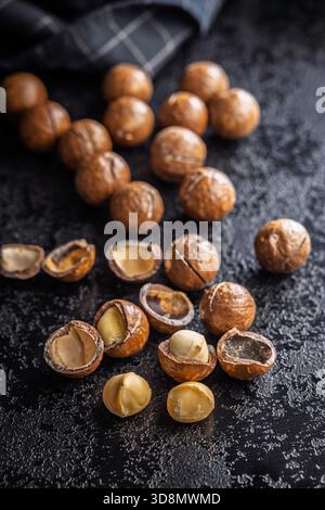 Tasty macadamia nuts on a black table. Stock Photo