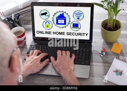 Online home security concept shown on a laptop used by a man Stock Photo