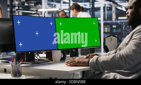 Data center software developer inspecting gear using isolated screen PC, doing maintenance tasks. Server room IT specialist using mockup computer, conducting system checks, close up Stock Photo