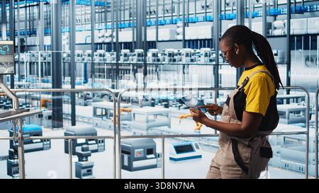 Smart factory engineer implements automated workflows using artificial intelligence tech, computerizing manual operations. Woman integrates sensors into production using AI technology, camera A Stock Photo