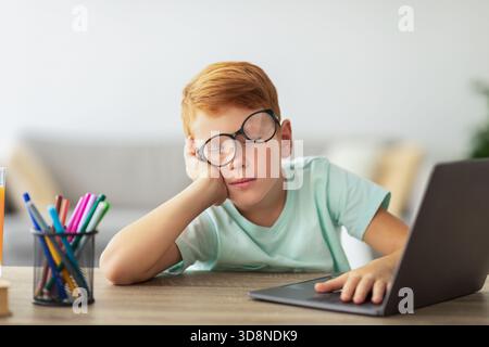 Exhausted Boy Falls Asleep While Doing Homework at the Desk During Study Time Stock Photo