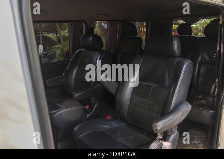 Comfortable black leather seat interior of modern passenger van. spacious vehicle for transportation and travel, showing empty seats ready for comfort Stock Photo