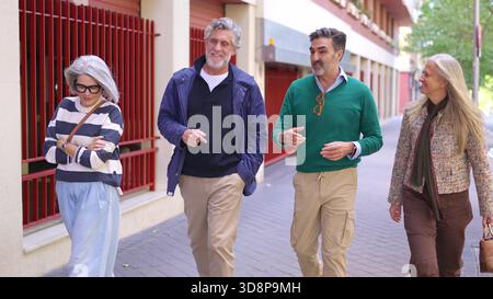 Two senior men talking while walking outdoors Stock Photo
