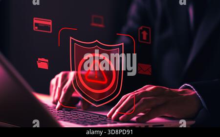 Cybersecurity concept with shield alert icon and man working on laptop, representing data protection, system security, cyber attack prevention, and di Stock Photo
