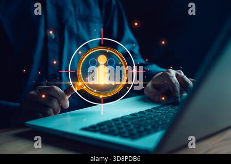 Recruiter using magnifying glass targeting best candidates on laptop, symbolizing HR analytics, talent acquisition, employee search, or workforce opti Stock Photo
