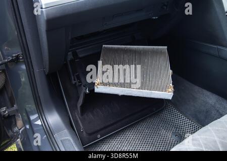 Old dirty carbon cabin filter of the car. Concept of replacement with a new one. Cleaning the air in the car cabin Stock Photo