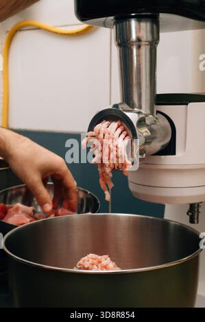 Chef makes minced meat using an electric meat grinder. High quality photo Stock Photo
