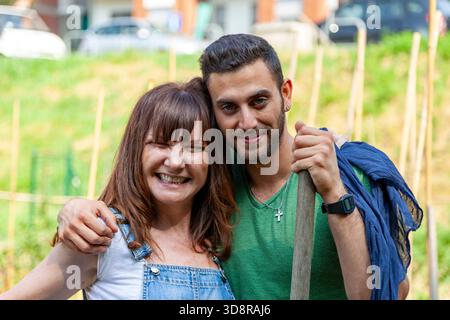 Couple working and spending time together in a garden, actively embracing Stock Photo