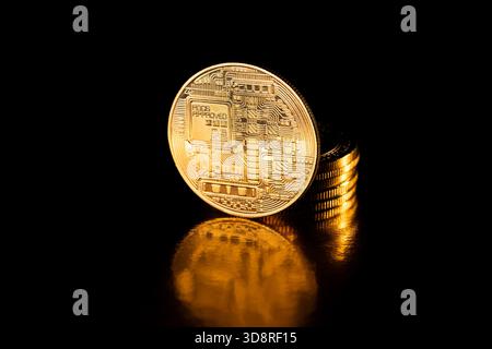Golden Bitcoin, crypto currency. Bitcoin coin isolated on black background. Stack of gold coins with Bitcoin coin in front of it. Cryptocurrency. Stock Photo