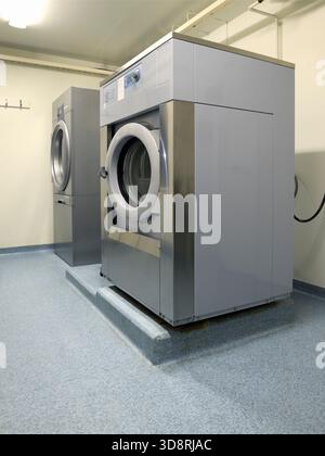 Shared apartment building laundry room with washing machine Stock Photo