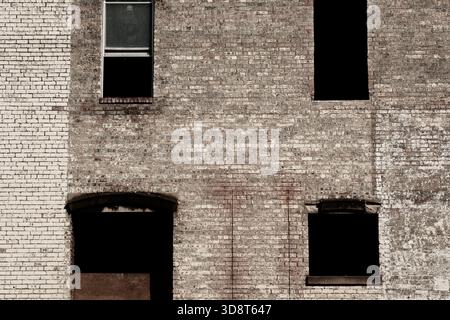 Brick facade and empty windows on old building Stock Photo