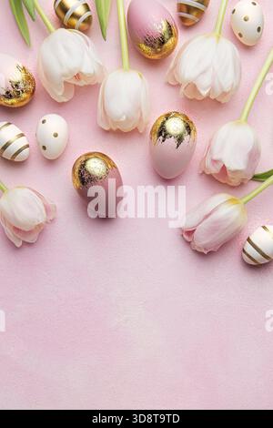 Easter golden eggs and pink tulips on pink background. Top view. Happy Easter composition. Greeting card. Stock Photo