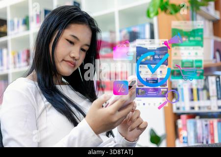 Woman using smartphone for online shopping with digital icons, mobile payment, discount promotion, ecommerce browsing, modern retail technology and di Stock Photo
