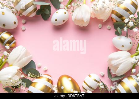 Easter golden eggs and white tulips on pink background. Top view. Happy Easter composition. Greeting card. Stock Photo