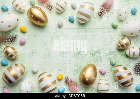 Decorative colored Easter eggs on a green wooden background. Festive background with place for text. The concept of Easter holidays. Stock Photo