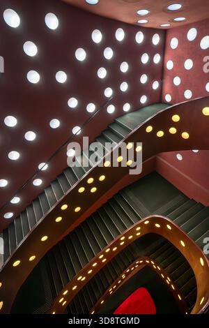 View of an upward shot of a staircase with white circular lights on the walls and yellow lights on the banister, Suginami City, Tokyo, Japan. Stock Photo