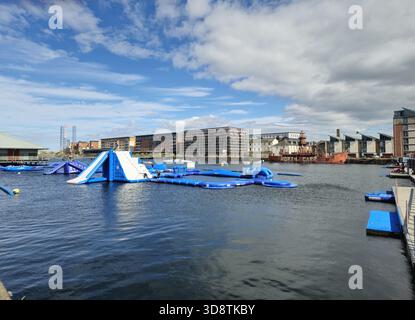 Watersports and aqua park, Wild Shore Dundee near the City Quay. At the background, North Carr, a lightship moored in Victoria Dock, Dundee, Scotland Stock Photo