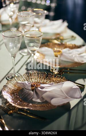 Sunlit close-up of luxury table setting with glowing crystal glasses Stock Photo