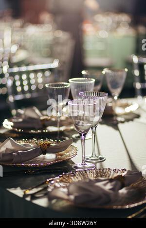 Sunlit close-up of luxury table setting with glowing crystal glasses Stock Photo