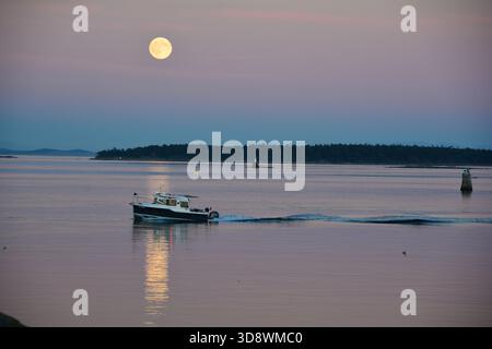 Coming back on a full moon evening in my boat. Stock Photo