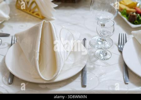 Elegant setting festive table with plates, napkins and cutlery Stock Photo