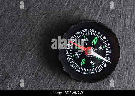 Compass on dark stone background. Top view with copy space Stock Photo