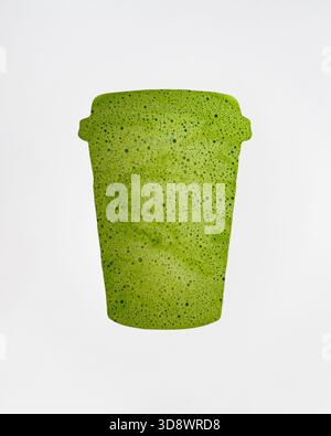 Matcha visible through a paper cup shaped gap on white background. Minimal creative healthy matcha to go concept. Trendy takeaway matcha drink idea. Stock Photo