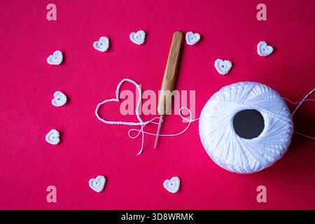 Handmade crochet hearts, romantic craft background, Valentine’s Day DIY scene. No people, studio shot, copy space. Stock Photo