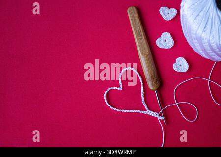 Handmade crochet hearts, romantic craft background, Valentine’s Day DIY scene. No people, studio shot, copy space. Stock Photo